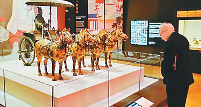 在英国利物浦世界博物馆“秦始皇与兵马俑”大型特展上，一名观众在铜车马复制品前驻足。