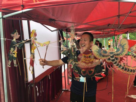 开幕式现场，孝义皮影第八代传人候建川展示皮影。